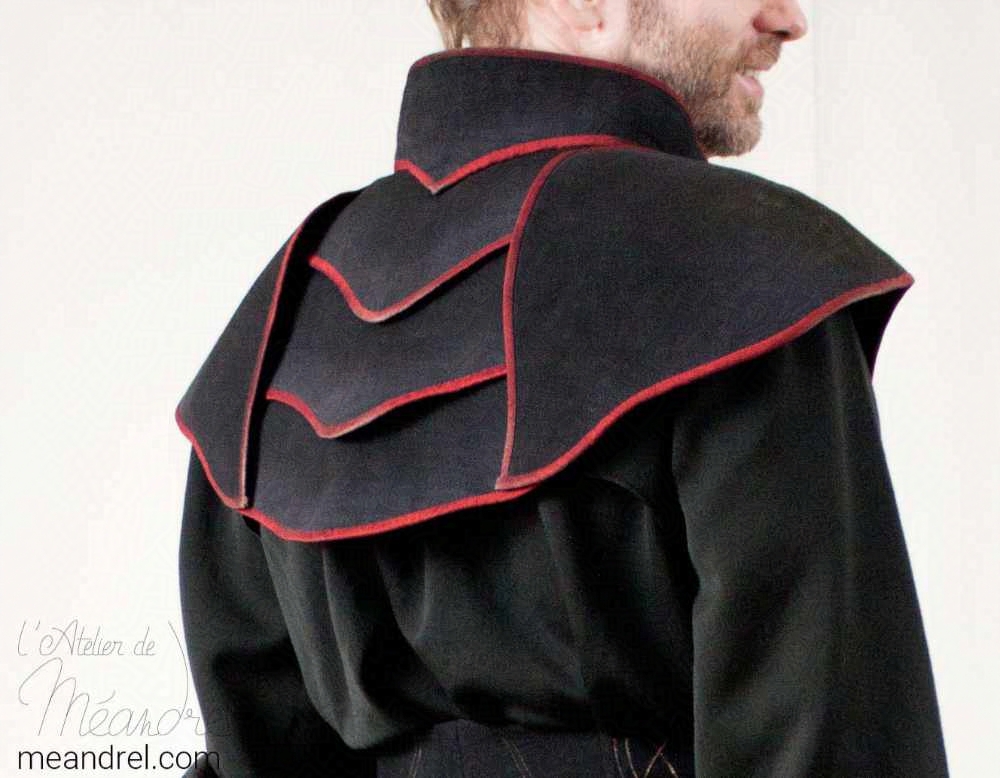Photo d'un dos de costume : des pièces d'armure noires au bords rouges couvrant les épaule et le dos.