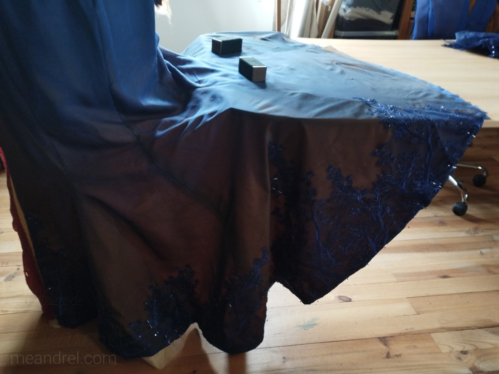 La dentelle en train d'être posée, étalée sur une table.