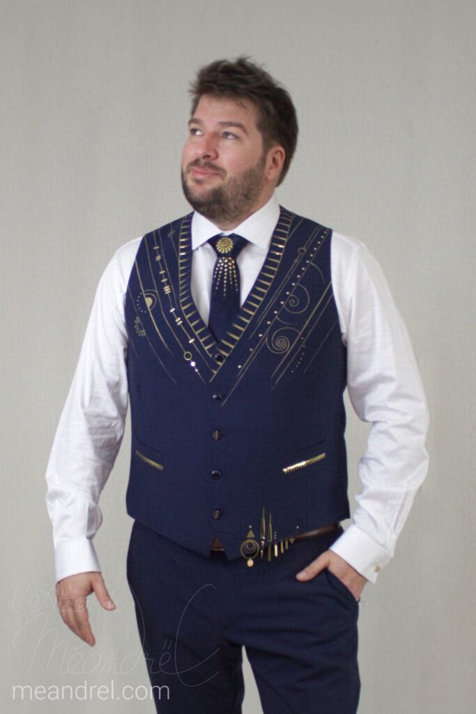 Photo du devant du gilet, bleu avec peintures or, assorties au dos (lignes en V, spirales, cercles...)