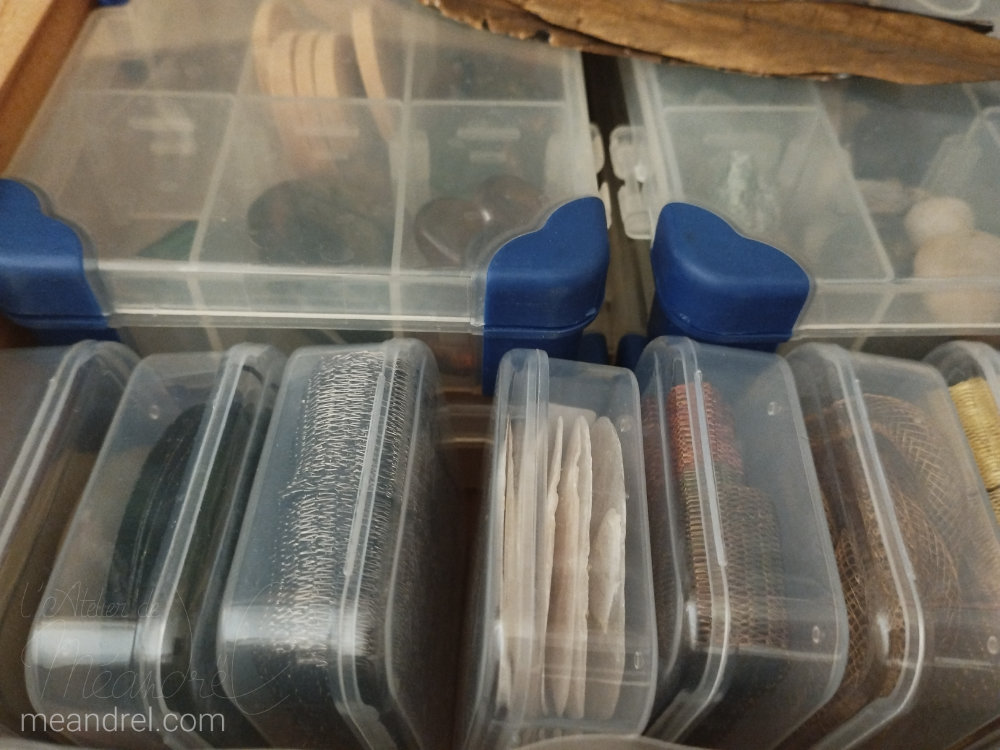 Tiroir vu du dessus, plein de boites carrées et de boites plates à compartiments.